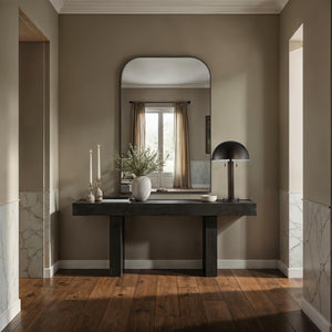 Opalina mirror in a modern entryway, featuring an arched black frame above a dark wooden console table.