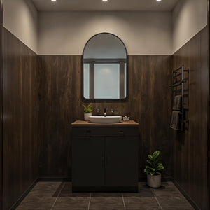 Cascais mirror installed above a modern bathroom sink with dark wood paneling.