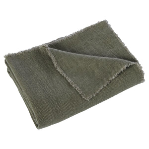 Pisces indoor pillow in olive green, folded with frayed edges, showcasing a textured fabric.