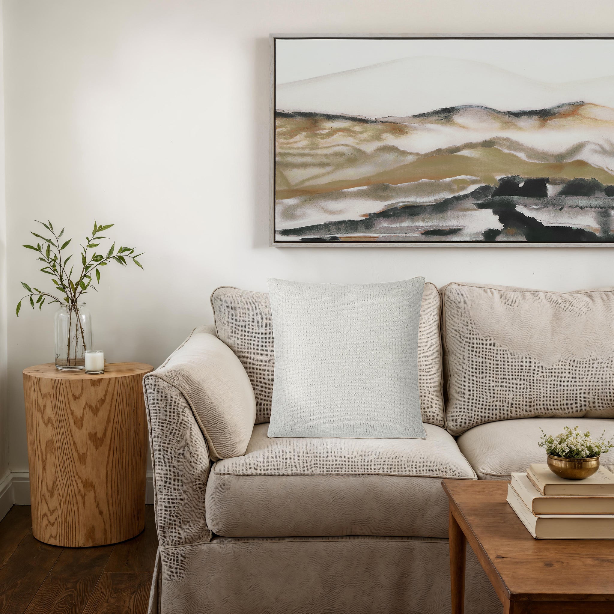 Bolero indoor pillow on a cozy beige couch next to a wooden side table.