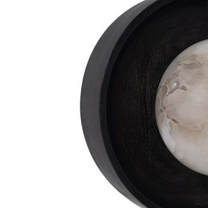 Haloa wall sconce featuring a round black wooden frame and an alabaster globe.