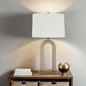 Primula table lamp on a wooden table, illuminating a cozy room
