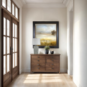 Aurelle table lamp on a wooden sideboard, paired with decorative items and a landscape painting.