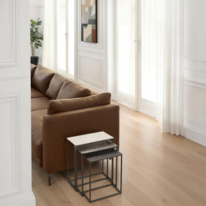 Manisa Table by Renwil, nesting tables beside a brown leather sofa in a bright living room.