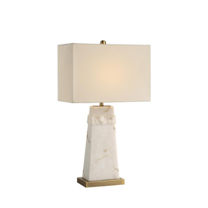 Nisrine Table Lamp illuminated, featuring a white shade and marble base with gold accents