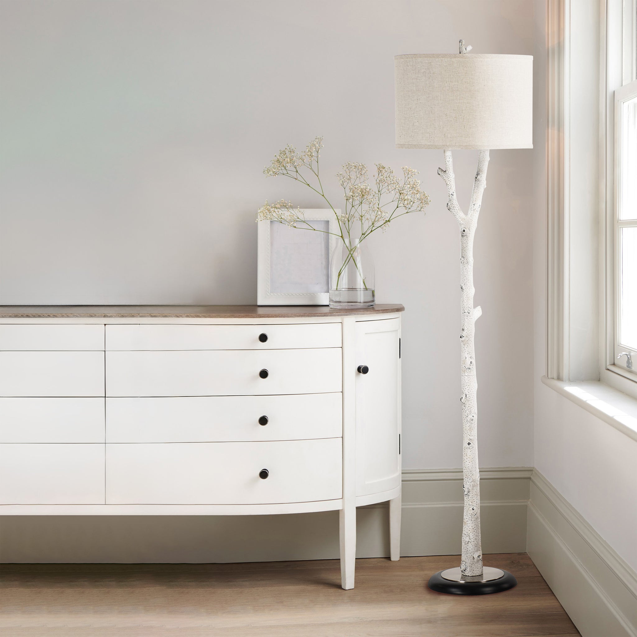 Criterion floor lamp positioned beside a white dresser with decorative flowers