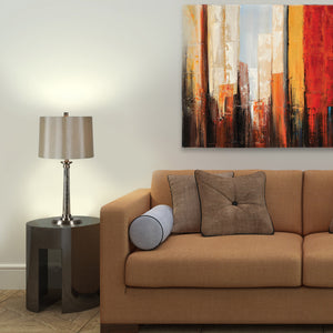 Brooks Set Of 2 Table Lamp beside a brown sofa, featuring a beige shade and metallic base.