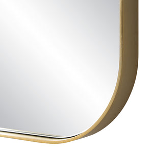 Close-up of the Vesey Wall Mirror's gold frame and rounded edge.