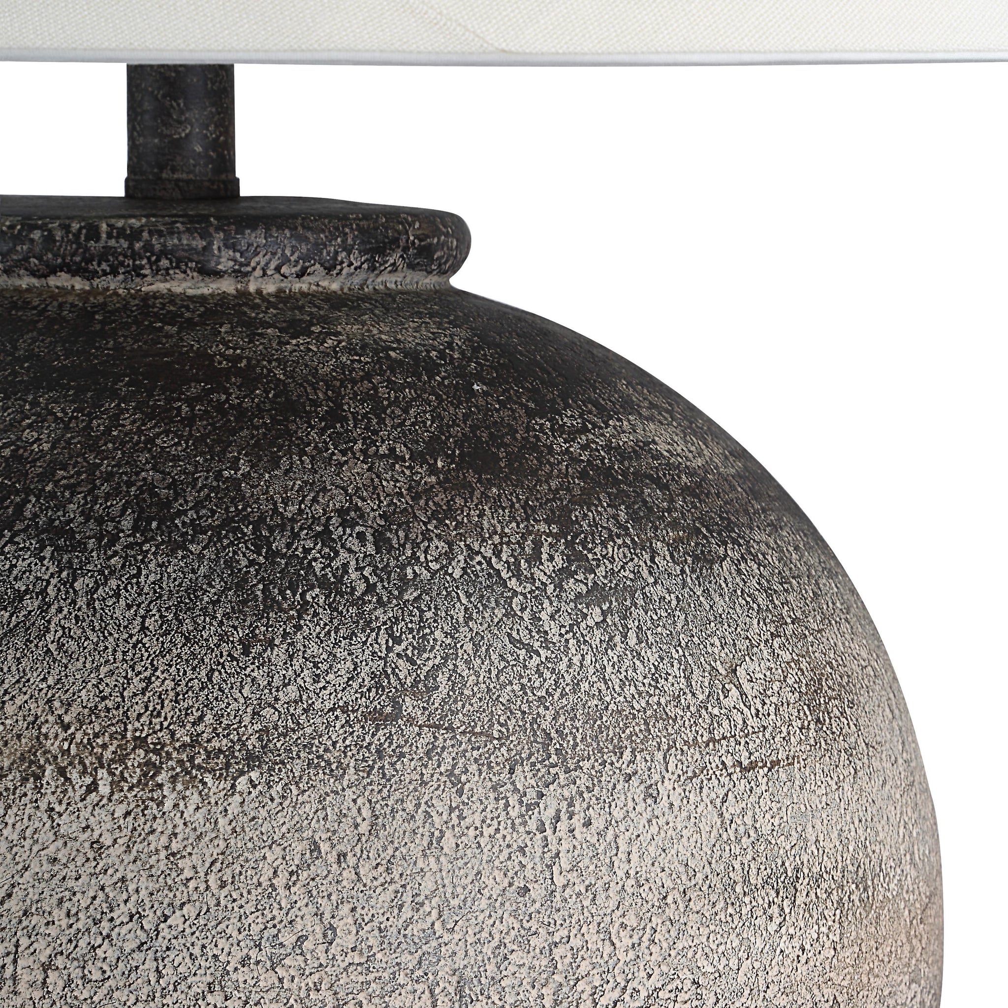 Close-up of Bronce Table Lamp's textured dark gray ceramic base and white shade