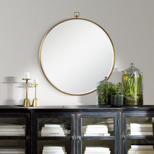 Azam Wall Mirror displayed on a wall above a dark wooden cabinet with decor items.