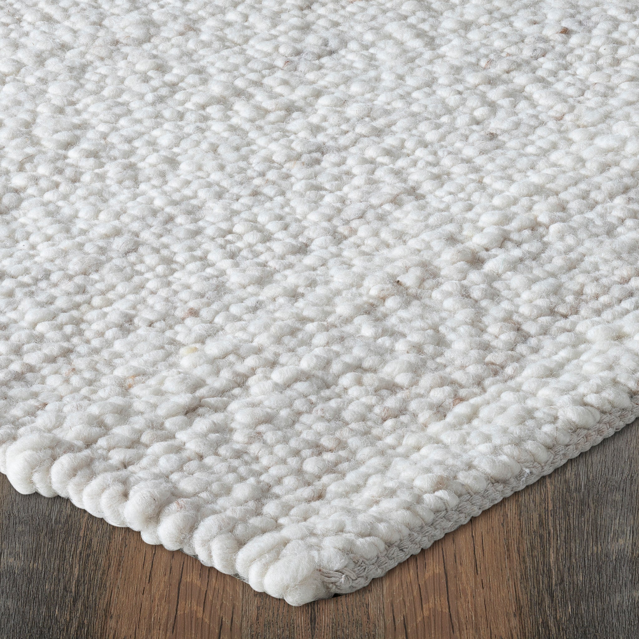Corner view of Meghan rug featuring a plush, textured surface in light beige with a soft finish.