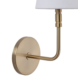 Close-up of Milia Wall Sconce showing gold metal arm and round base with white shade.