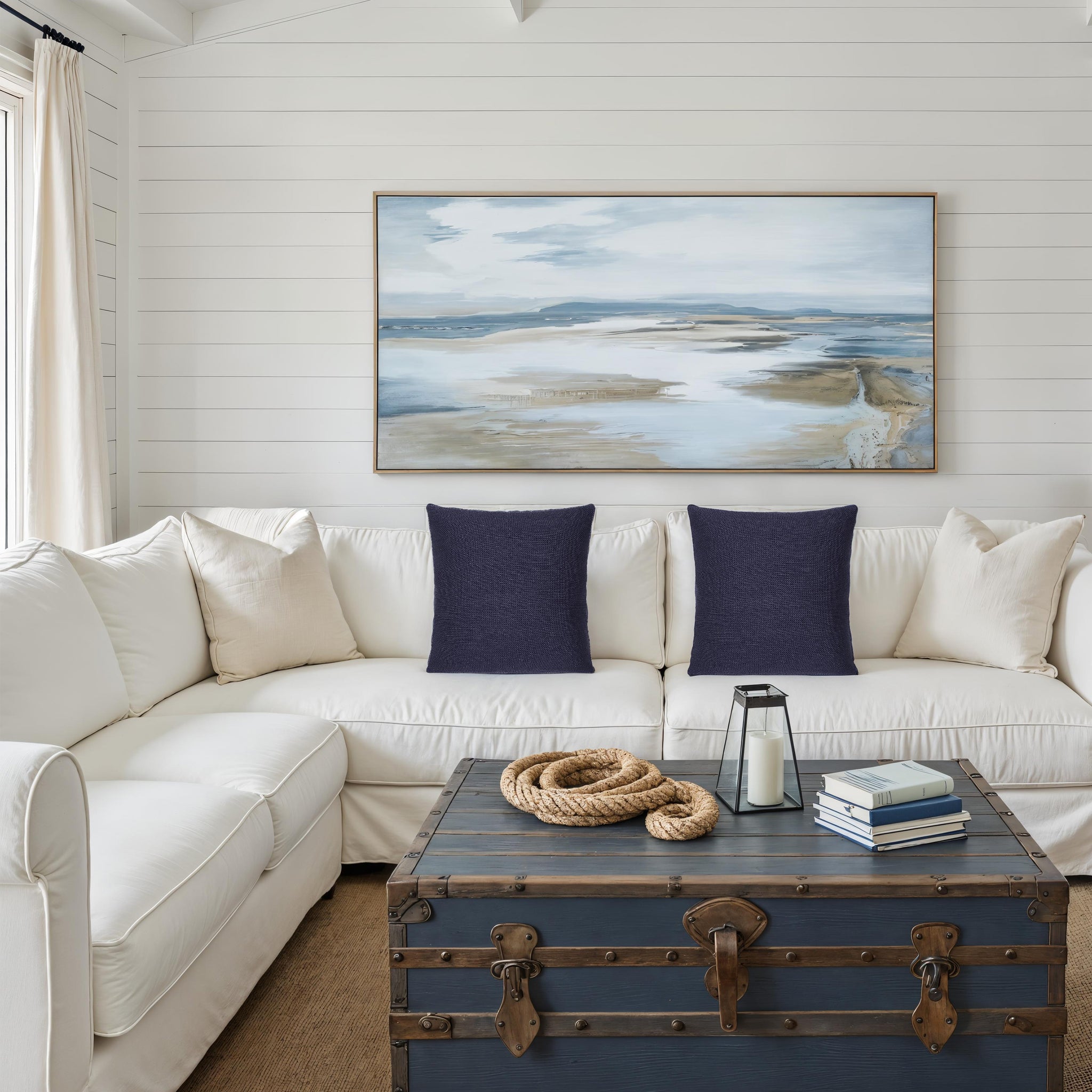Forester decorative pillows on a white sectional sofa with a coastal painting.