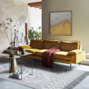 Threefold Indoor Aluminum Table beside a mustard yellow sofa in a stylish living room setting.