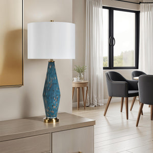 Milo Table Lamp in a modern living room setting, with a teal base and white shade on a wooden table.