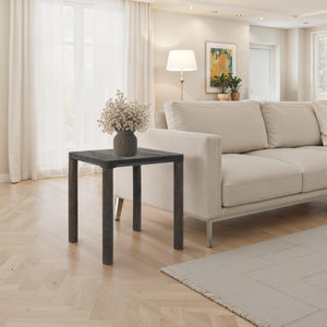 Clusia 19.0" Height Side Table placed beside a sofa, adorned with a decorative vase