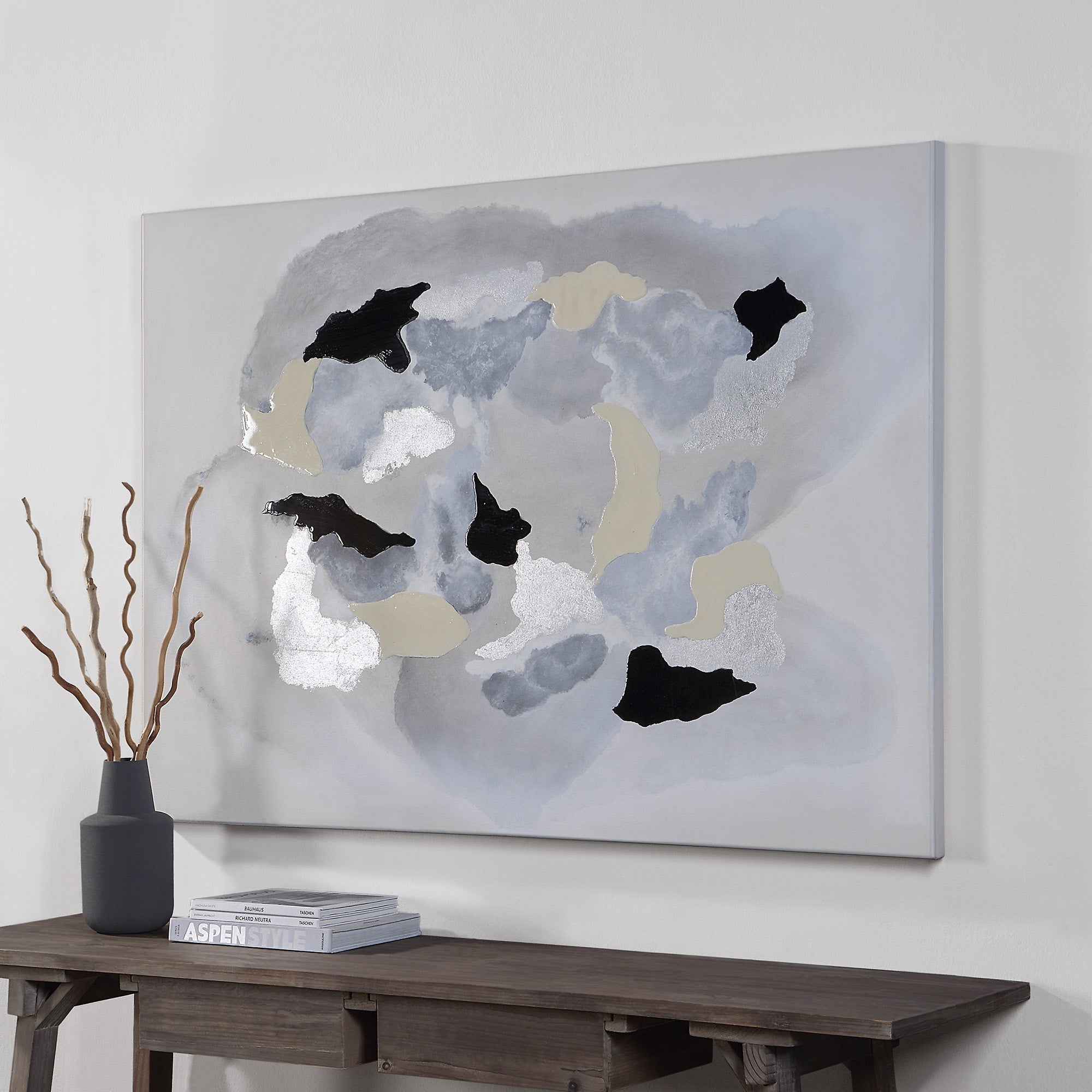 Alasia canvas art featuring abstract shapes in gray, black, and metallic silver on a light background, displayed on a wall.
