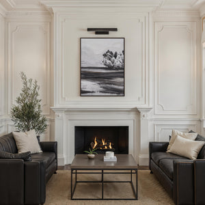 Nea wall sconce by Renwil installed in a stylish living room above a fireplace.