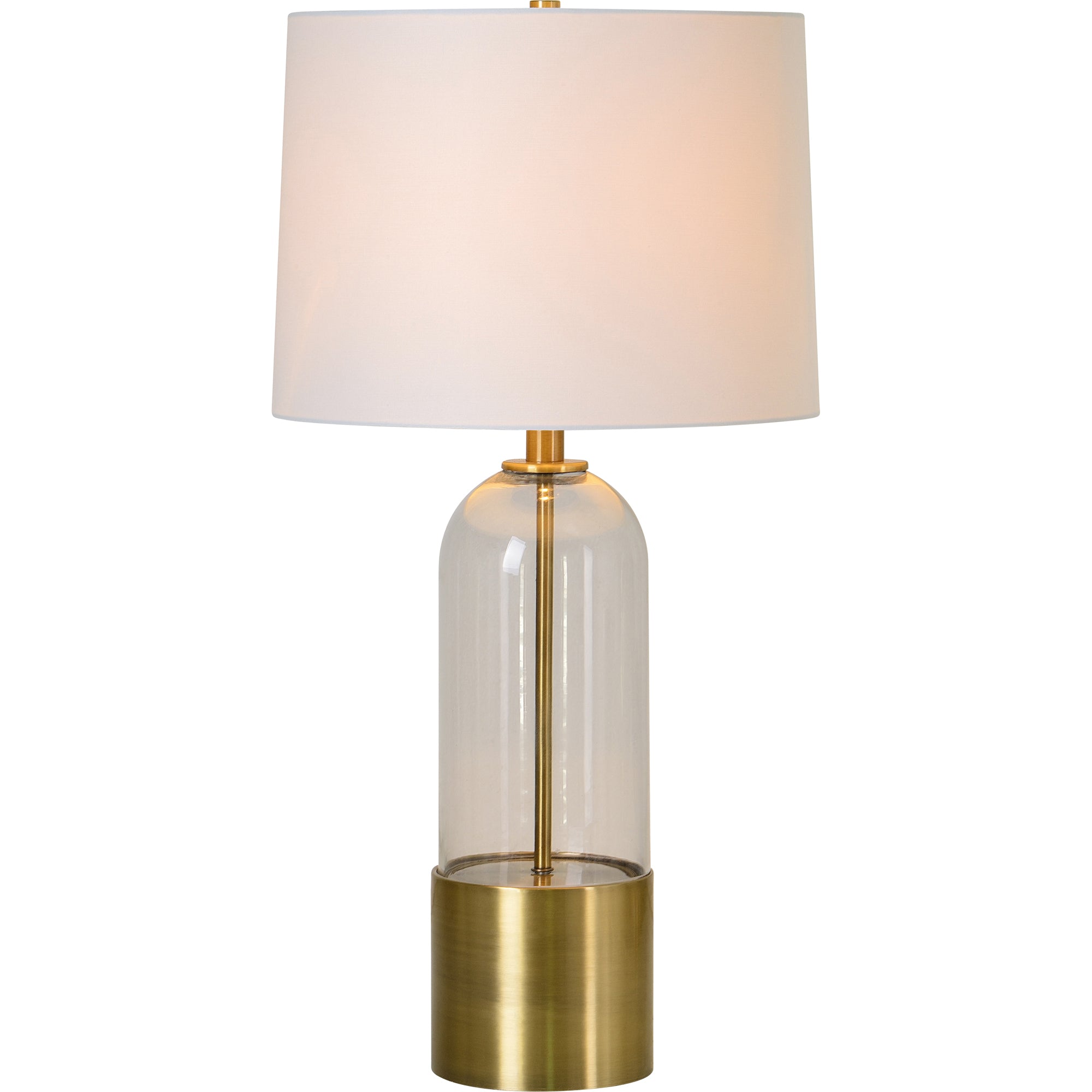 Theodore Table Lamp with a clear glass body, brass accents, and a white shade, illuminated softly.