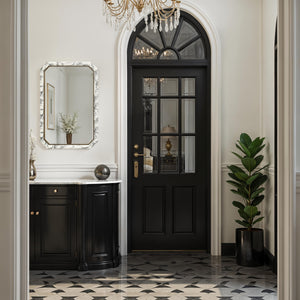 Venus mirror displayed in an elegant entryway with black door and furnishings