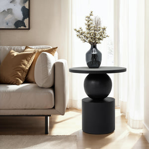 Paola side table styled with a vase and decorative elements beside a sofa.