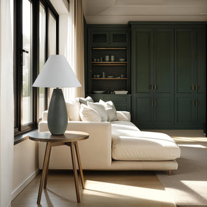 Olso Table Lamp on a round wooden side table next to a white sofa