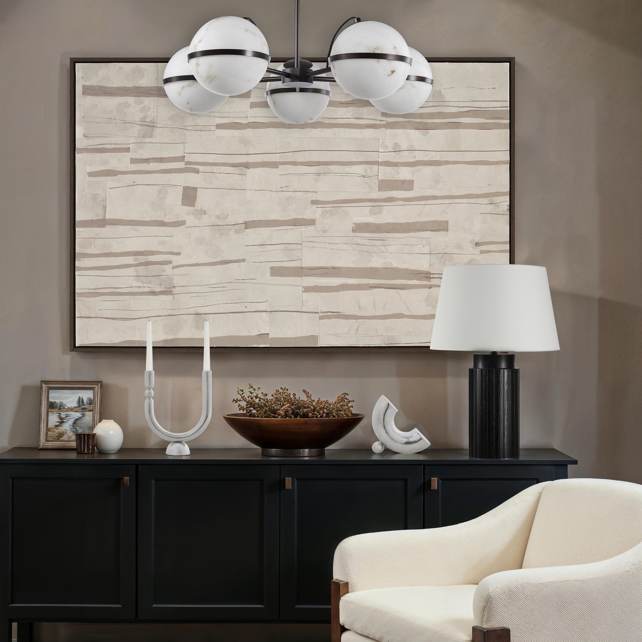 Sediment canvas art featuring abstract beige and brown lines, framed and displayed above a black cabinet.