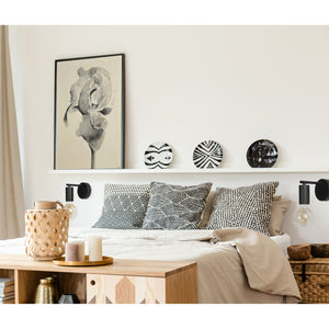 Think Wall Sconce styled in a modern bedroom with decorative pillows and wall art.